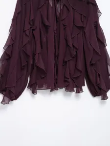 Close-up view of dark purple ruffle layered long sleeve shirt front detail and fabric texture.