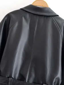 Back detail of women black faux leather jacket featuring lapel collar and waist belt accent.