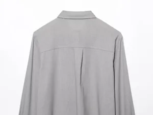 Vista posteriore dettagliata della camicia grigia a maniche lunghe con piega dietro.