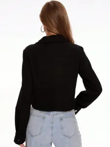 Detalle trasero de chaqueta camisa de lana negra corta, ajuste y cuello elegante.