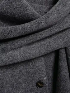 Close-up view of dark gray knit cardigan fabric texture, featuring scarf collar and button detail.
