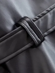 Close-up detail view of black leather trench coat belt loop and fine stitching texture.