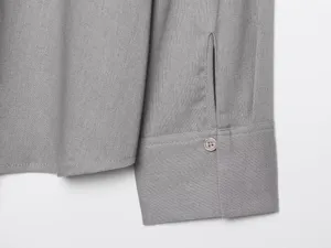 Primo piano del polsino e del bottone di una camicia a maniche lunghe tinta unita. Tessuto.