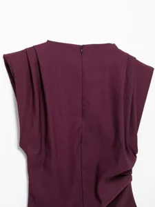 Back detail of purple pleated top with shoulder pads and zipper closure for women.