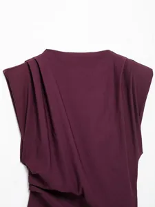 Close-up view of asymmetric pleated shoulder pad top detail, elegant purple fabric texture.