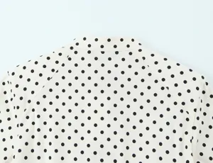 Close-up detail of the cream and black polka dot long sleeve blouse back design.