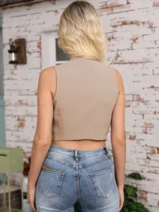 Back view of a solid color sleeveless cropped vest paired with blue denim jeans, elegant look.