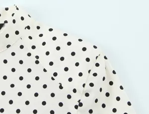 Close-up detail of women polka dot long sleeve shirt shoulder, elegant pattern fabric.