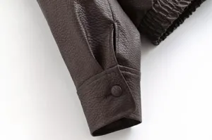Gros plan détaillé de la manche de veste en similicuir marron pour femme avec poignet.
