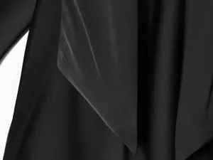 Detail shot of black satin fabric, showcasing smooth drape, elegant collar fold, and texture.