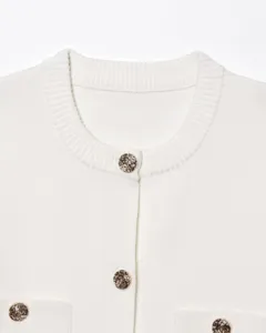 Cardigan tricoté blanc col rond pour femme détail, boutons métal élégants et doux.