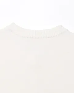 Gros plan détail d'un cardigan tricoté blanc pour femme à col rond, texture douce.