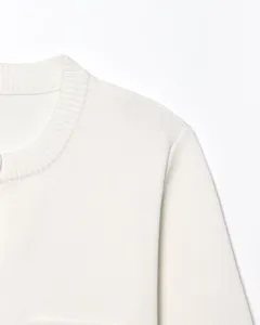 Vue de détail d'un cardigan en tricot blanc, mettant en valeur le col côtelé fin et la texture.