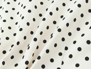 Polka dot fabric detail close up of women fashion clothing apparel texture surface style.
