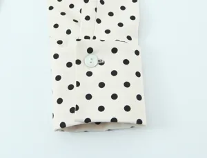 Polka dot shirt sleeve detail, long sleeve casual wear, classic black and white print.