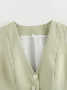 Close-up detail of women's sage green V-neck vest top, showing white lining and button.