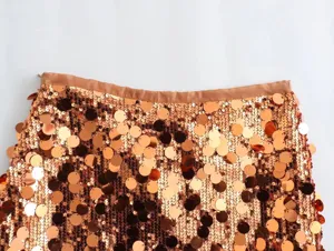 Close-up of sparkling rose gold sequin mini skirt detail, chic high waist party wear.