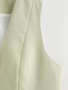 Close-up detail of women sage green waistcoat fabric lapel, elegant tailored vest texture.