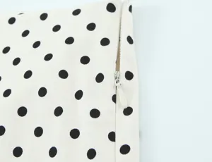 Close-up detail of classic black and white polka dot fabric with neat invisible zipper design.