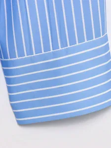Close-up of blue and white striped shirt cuff, showing detailed fabric and stitching.