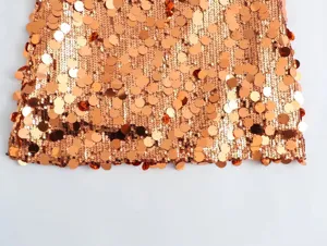 Stunning copper sequin mini skirt fabric detail, high-density sparkle design for women's party wear.