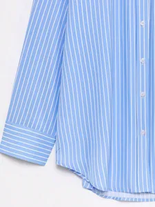 Blue and white striped shirt detail showing buttons and cuff design for women fashion.