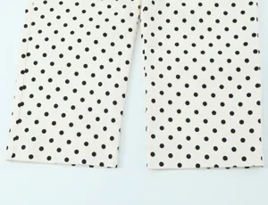 Detail view of high-waisted polka dot pants showcasing fabric texture and classic pattern.