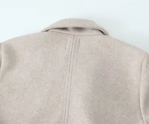Vue détaillée du col arrière et de la couture sur un manteau en laine uni pour femmes.