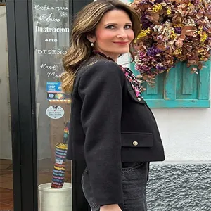 Classic black short tweed jacket featuring elegant gold buttons and stylish pocket details.