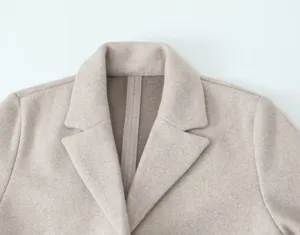 Gros plan sur le col à revers d'un manteau en laine pour femme, texture douce, belle finition.