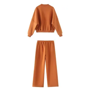 Detailed view of the cozy orange sweatshirt and wide-leg trousers set, comfortable fabric.