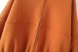 Detailed view of women's zip-up jacket sweatshirt in rust orange with front zipper.