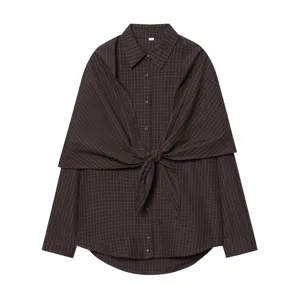 Detail of dark brown plaid long sleeve shirt with front tie knot and lapel collar.