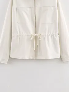 Detailed view of women's off-white zip-up jacket with chest pockets and waist drawstring.