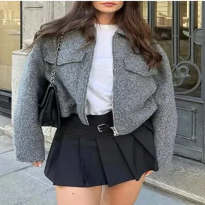 Women's autumn casual cropped tweed jacket paired with chic pleated skirt and shoulder bag.