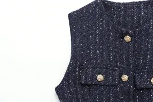 Navy blue tweed vest detail featuring metallic gold buttons and textured bouclé fabric.
