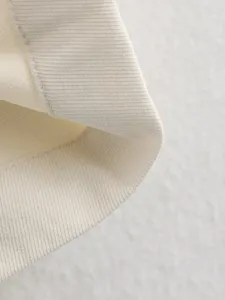 Close up view of soft ribbed knit fabric texture, showing fine details and neat sewing.