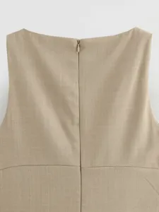 Detailed view of the back zipper and waist seam on a solid khaki sleeveless dress.