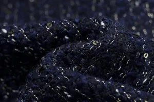 Close-up view of the dark blue textured fabric with metallic threads and subtle shimmering details.