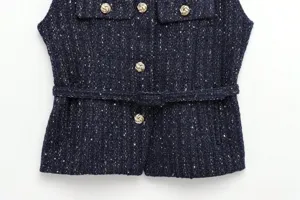 Detail shot of navy blue tweed vest with metallic gold buttons and matching belt for women.