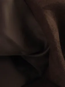 Doublure interieure de veste en daim et detail de tissu, couleur marron, gros plan.