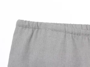 Dettaglio della cintura elastica dei pantaloni grigi, tessuto morbido e cuciture pulite.