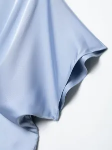 Close-up detail shot of light blue satin dress sleeve, elegant smooth fabric texture.