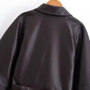 Back view detail of a chic dark brown short leather trench coat with lapel and belt.