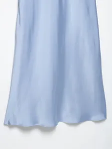 Satin dress hem detail, light blue fabric texture close-up, elegant skirt drape display.