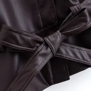 Close-up of brown leather trench coat belt with elegant bow tie detail and neat stitching.