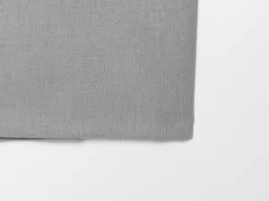 Dettaglio del tessuto grigio del set da donna con camicia a maniche lunghe e pantaloni.