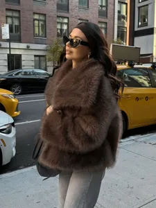 Detailed view of the stylish brown faux fur jacket worn on city street for modern outfits.