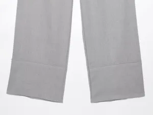 Dettaglio orlo pantaloni larghi grigi, tessuto morbido, cuciture pulite, stile casual chic.
