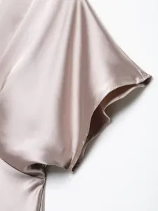 Close-up detail of women's silk satin dress sleeve, elegant texture and smooth fabric.